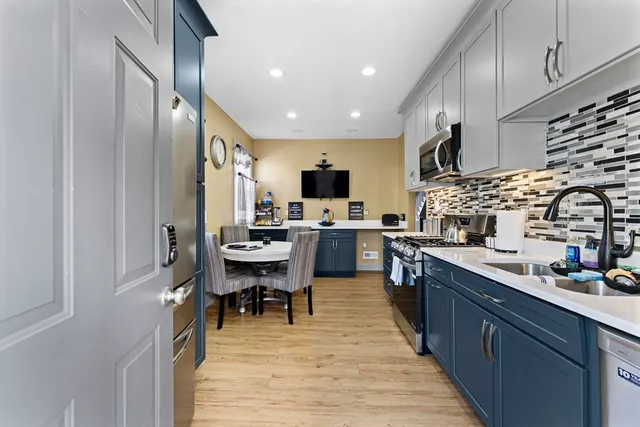 a kitchen with stainless steel appliances lots of counter top space and furniture