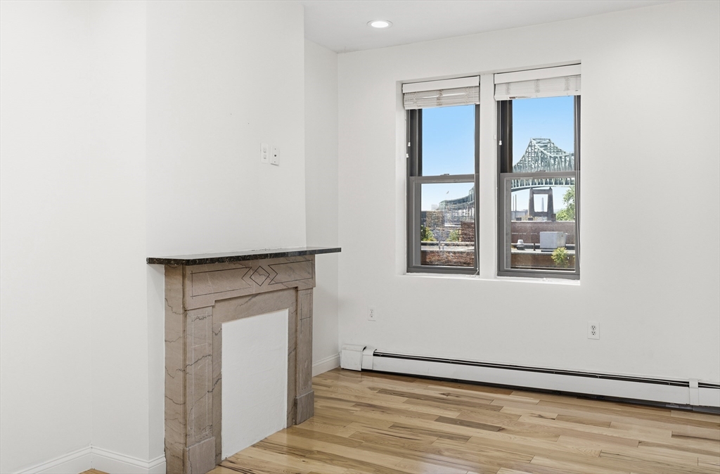 54 Beacon Street, Unit 2 Chelsea, MA 02150 - Photo 8 of 26 a view of an empty room with wooden floor and a window
