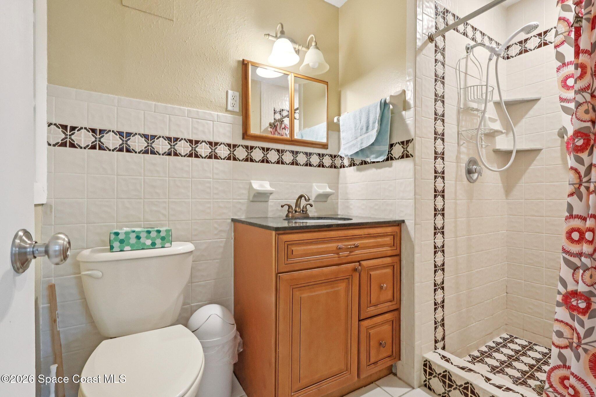1945 Madison Avenue Melbourne, FL 32935 - Photo 22 of 33 a bathroom with a granite countertop toilet sink and mirror