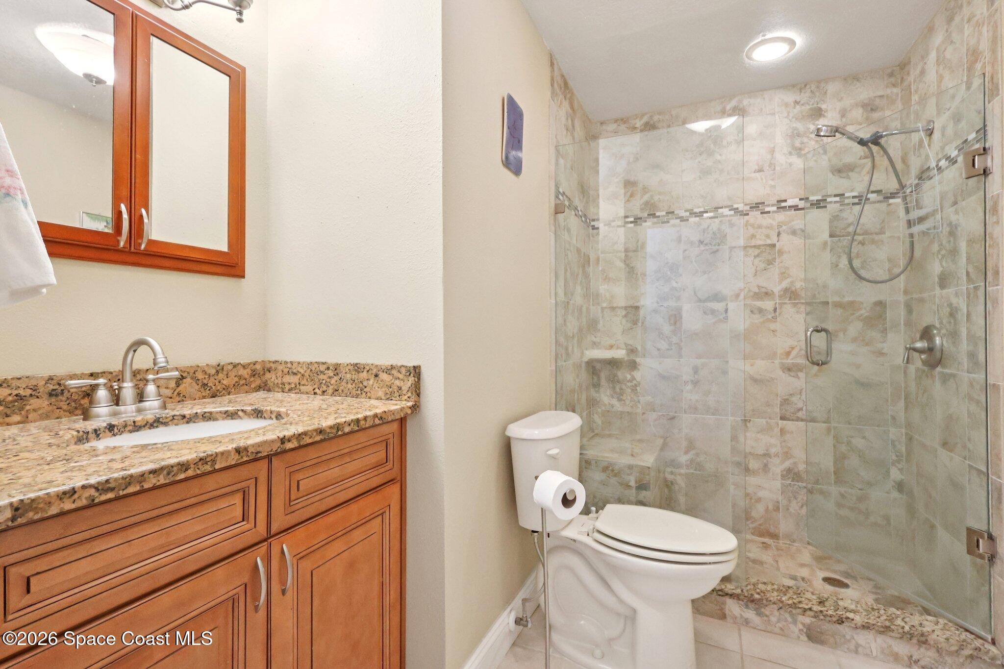 1945 Madison Avenue Melbourne, FL 32935 - Photo 26 of 33 a bathroom with a granite countertop sink toilet and shower