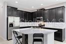 7601 Ripplepointe Way Windermere, FL 34786 - Photo 8 of 30 a kitchen with stainless steel appliances kitchen island granite countertop a sink and cabinets