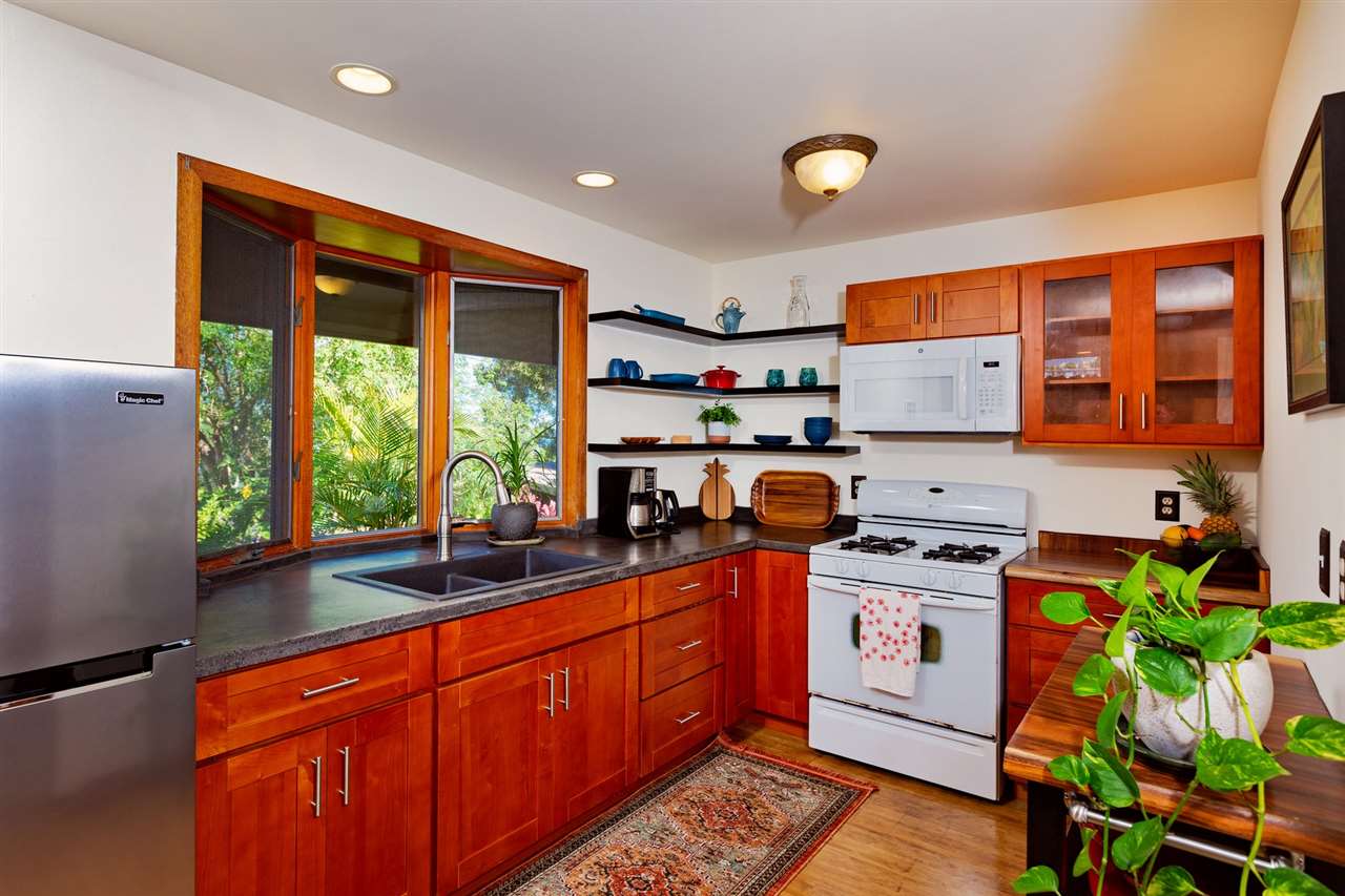 718 Holopuni Road Kula, HI 96790 - Photo 8 of 21 a kitchen with stainless steel appliances granite countertop a stove a sink and a microwave