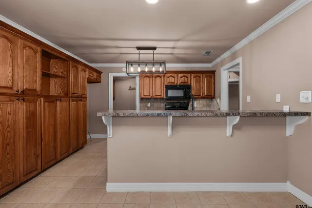 a kitchen with granite countertop a sink stainless steel appliances and cabinets