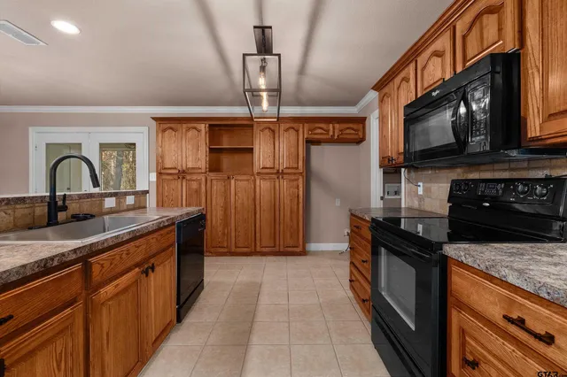 a kitchen with granite countertop a stove microwave and refrigerator