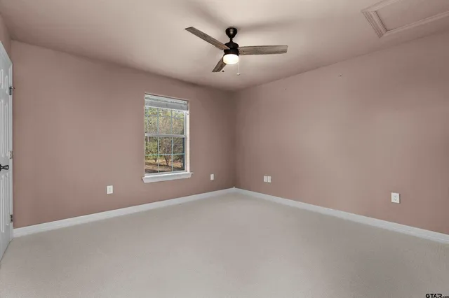 a view of an empty room with a ceiling fan