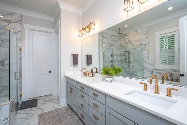 a bathroom with a double vanity sink mirror and shower