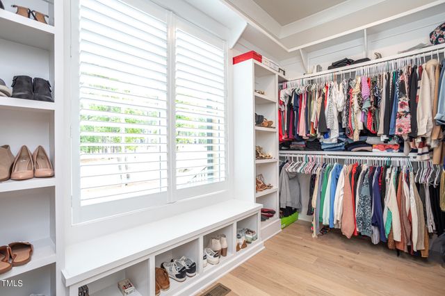 a view of walk in closet with clothes and shoes