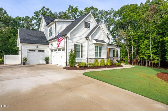a front view of a house with a yard and potted plants