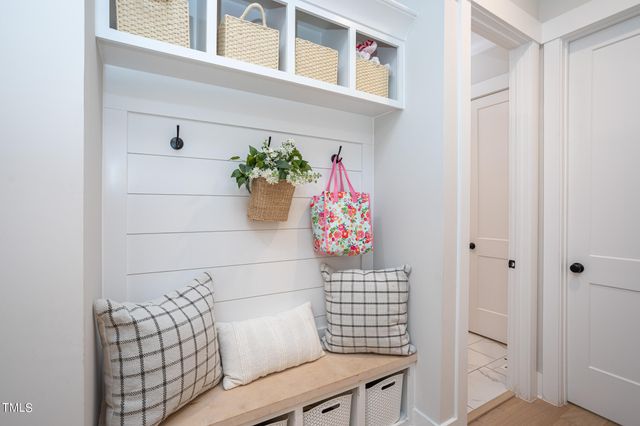 a view of a hallway with wooden floor and a potted plant