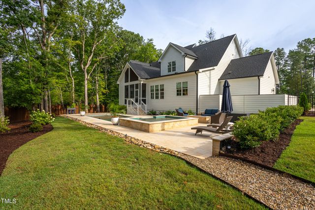 a view of a house with swimming pool and sitting area