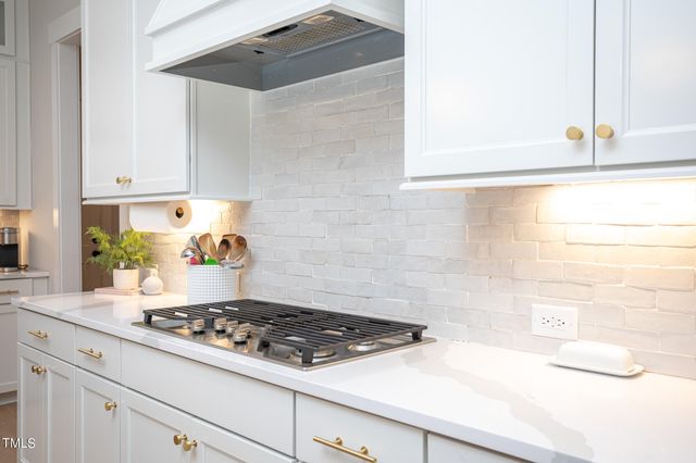 a kitchen with a stove and white cabinets