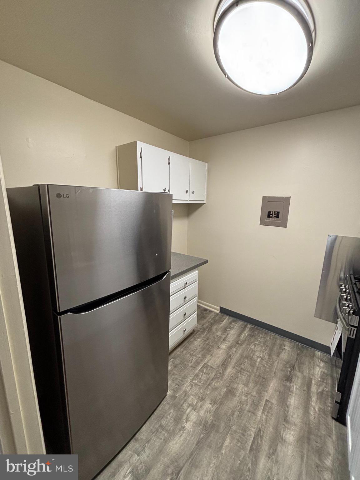 3827 St Barnabas Road, Unit T 103 Suitland, MD 20746 - Photo 5 of 15 a kitchen with a refrigerator and a mirror