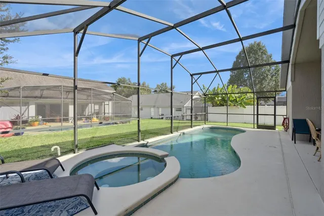 a swimming pool with view of lake view and a yard