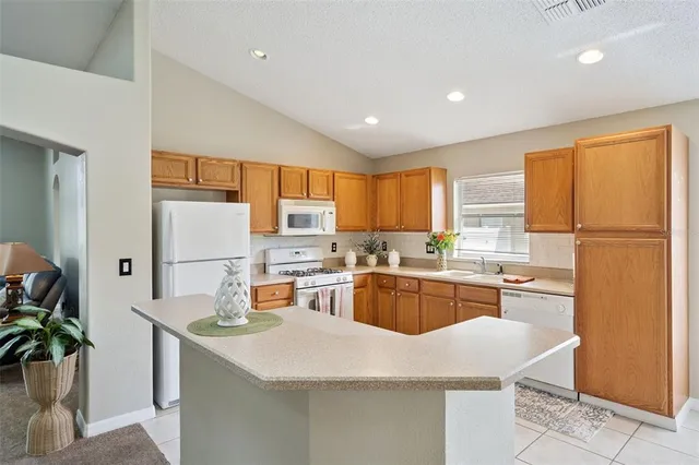 a kitchen with sink a refrigerator and wooden cabinets