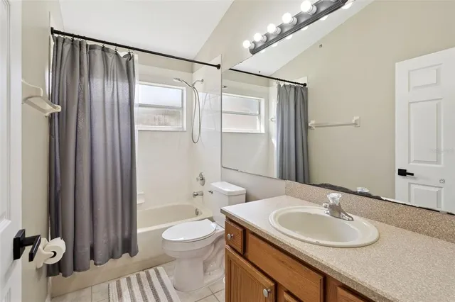 a bathroom with a granite countertop sink a toilet a mirror and shower