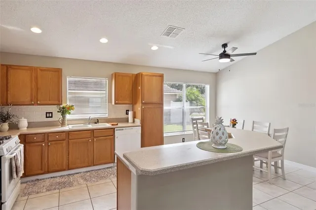 a kitchen with a sink a stove a refrigerator and island
