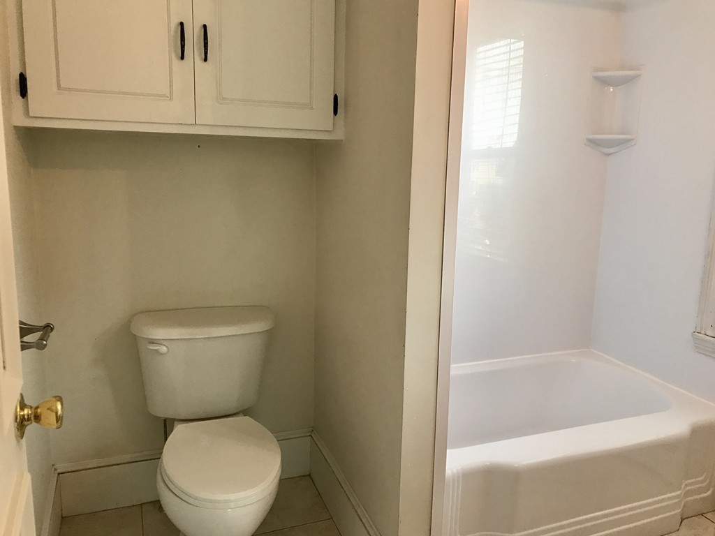 27-29 Topsfield Road, Unit 4 Ipswich, MA 01938 - Photo 13 of 22 a white toilet sitting next to a bathtub