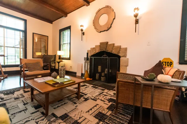 a living room with couches a dining table and chairs with wooden floor