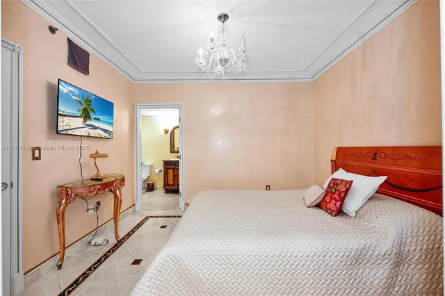 a bedroom with a large bed and a chandelier