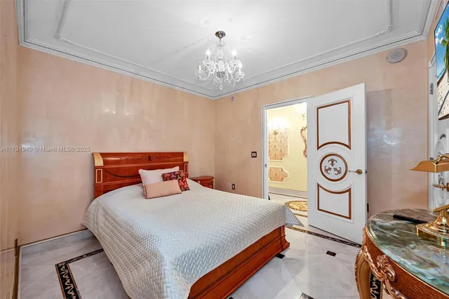 a bedroom with bed and a chandelier