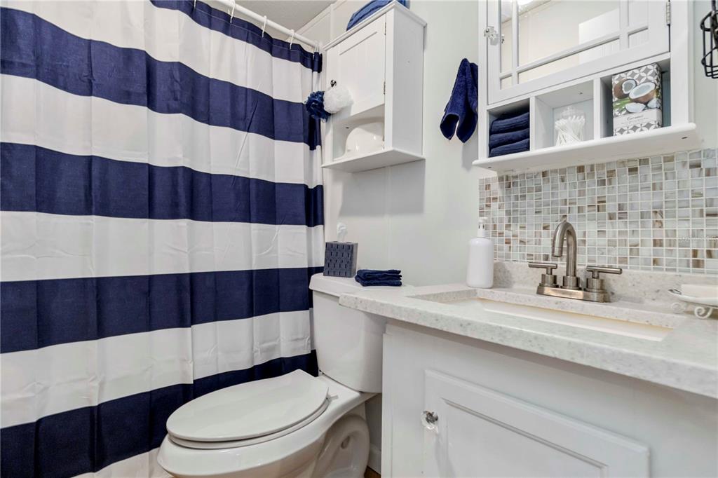 10303 Burnt Store Road, Unit 230 Punta Gorda, FL 33950 - Photo 18 of 27 a bathroom with a sink a toilet and shower curtain