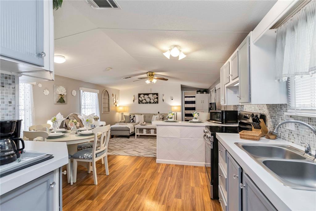10303 Burnt Store Road, Unit 230 Punta Gorda, FL 33950 - Photo 2 of 27 a kitchen with a sink dishwasher stove and wooden cabinets
