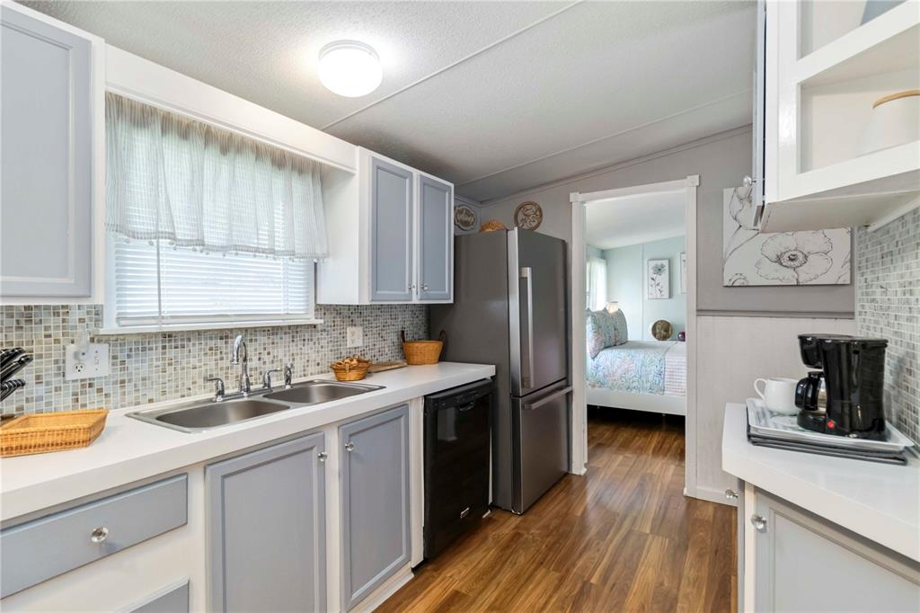 10303 Burnt Store Road, Unit 230 Punta Gorda, FL 33950 - Photo 3 of 27 a kitchen with a sink a refrigerator and cabinets