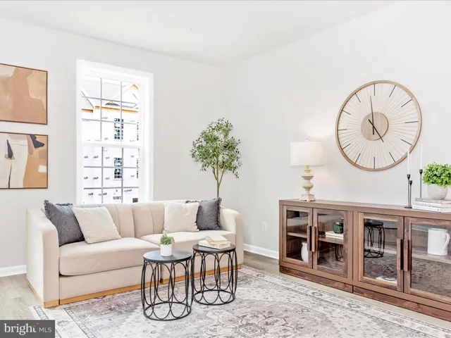a living room with stainless steel appliances granite countertop furniture wooden floor and a view of kitchen