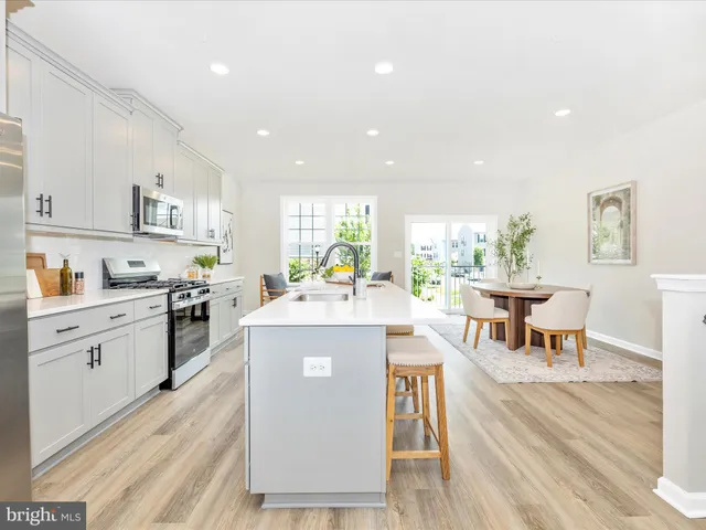 a large kitchen with stainless steel appliances and white cabinets