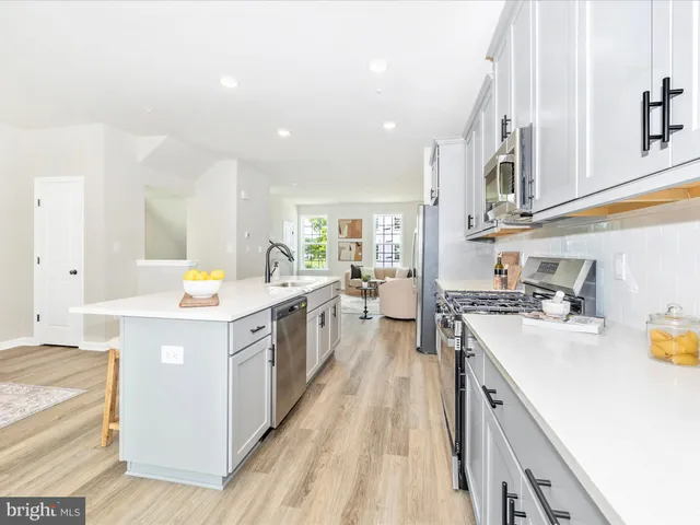 a kitchen with a sink a stove and white cabinets