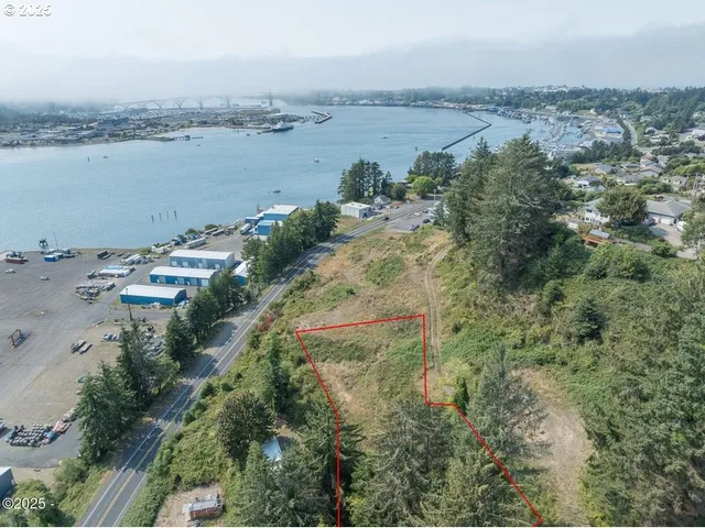 an aerial view of ocean with residential house with outdoor space and trees around