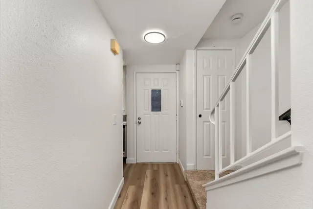 a view of a hallway with wooden floor and staircase