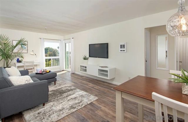a living room with furniture wooden floor and a flat screen tv