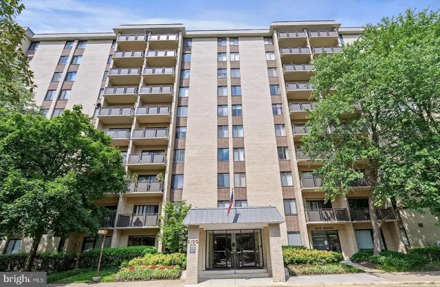 a front view of a multi story building with a yard