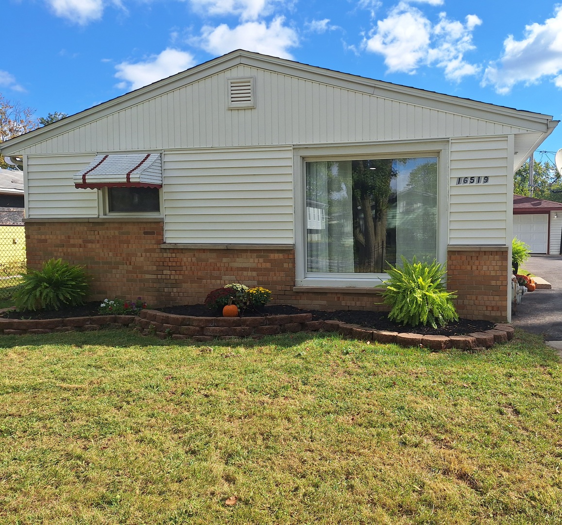 16519 Honore Avenue Markham, IL 60428 - Photo 3 of 26 a front view of a house with garden