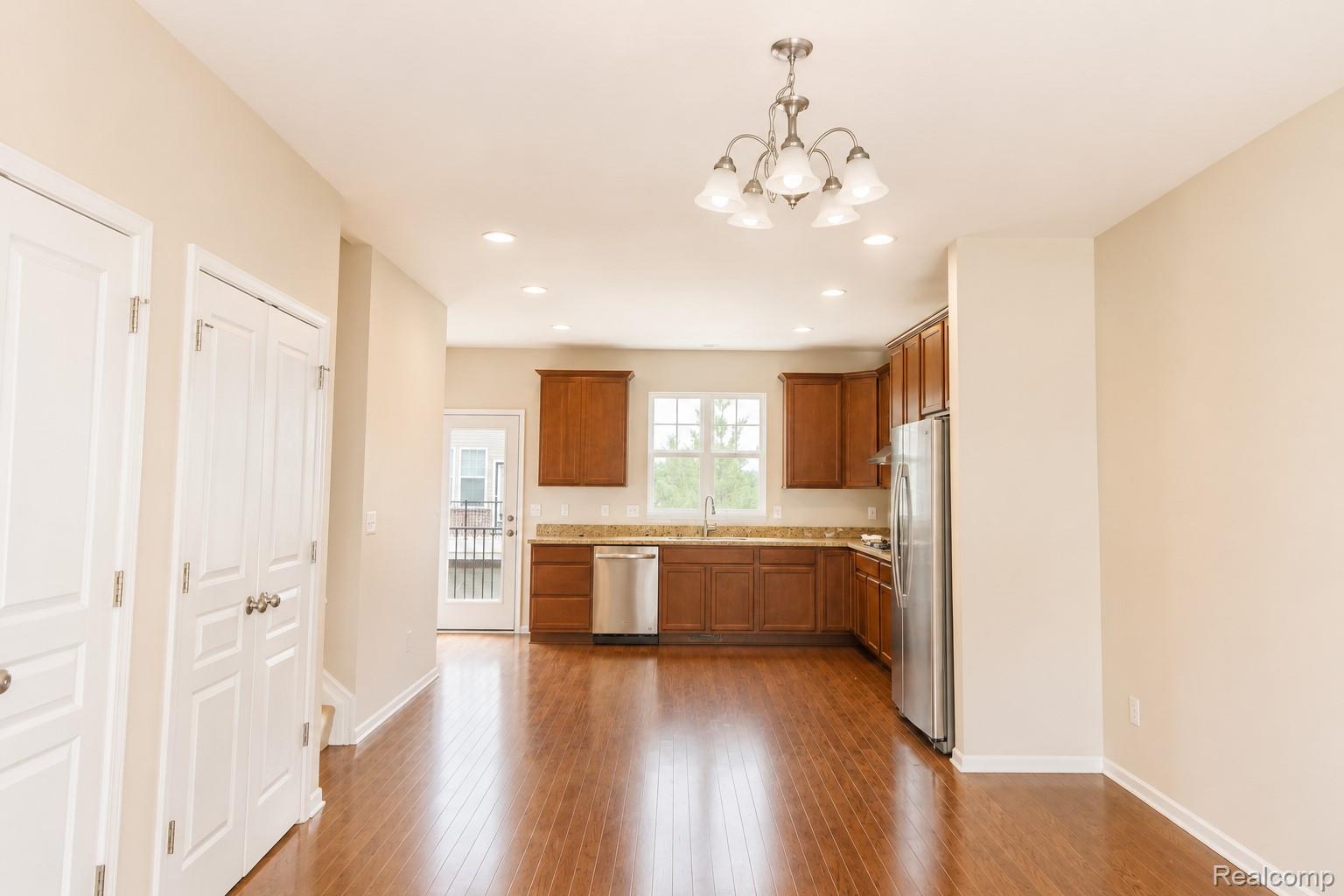 2940 Glenbar Circle Rochester, MI 48307 - Photo 5 of 15 Open-concept living area featuring rich wood-finish flooring, a contemporary chandelier, and recessed lighting