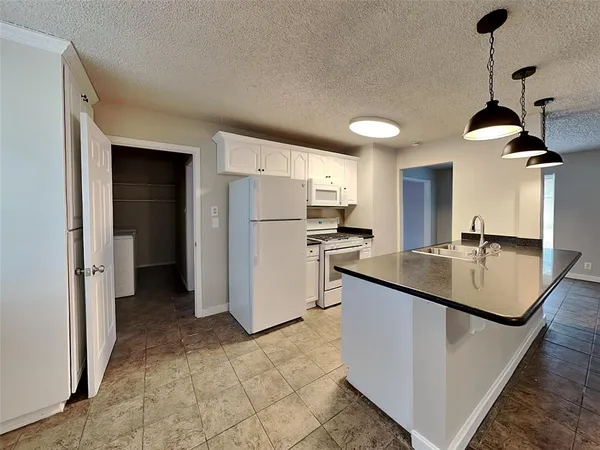 a kitchen with stainless steel appliances granite countertop a sink a refrigerator and a stove
