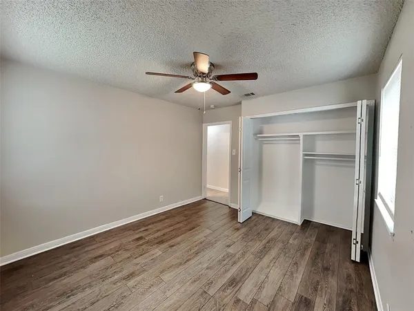 a view of a room with wooden floor and ceiling fan