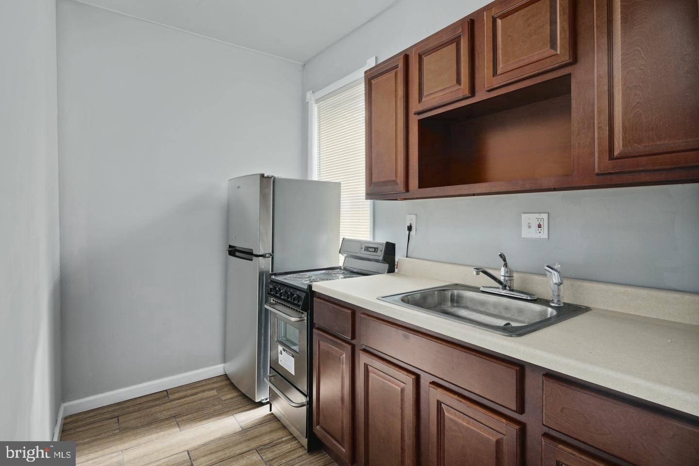 3428 North 23rd Street, Unit 3 Philadelphia, PA 19140 - Photo 6 of 14 a kitchen with stainless steel appliances granite countertop a sink refrigerator and microwave
