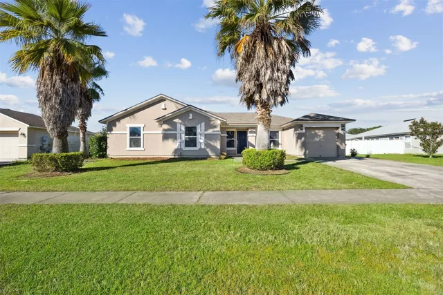 a front view of a house with a garden and trees