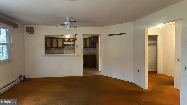 a view of an empty room with window and cabinet