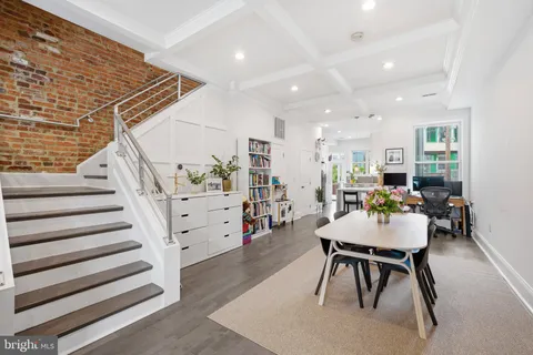 a room with lots of white furniture and stairs