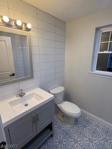 a bathroom with a sink a toilet and mirror