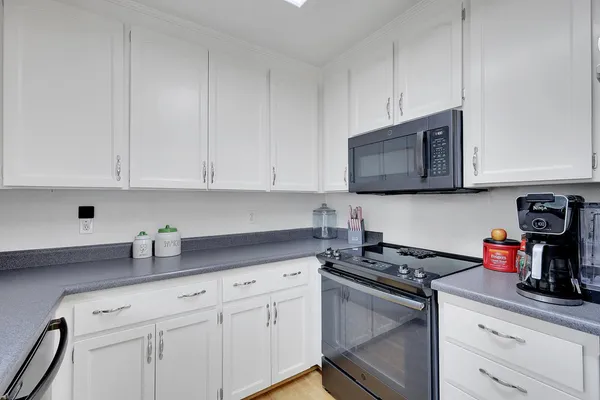 a kitchen with stainless steel appliances granite countertop white cabinets sink and dishwasher