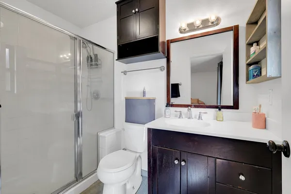 a bathroom with a sink a toilet and shower