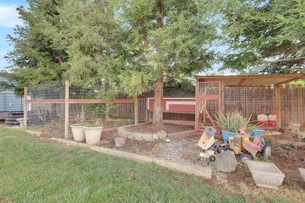 a view of a backyard with couches chair and wooden fence
