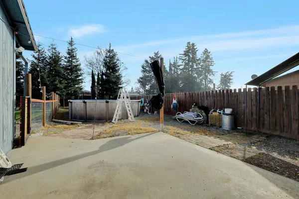 a view of backyard with furniture and trees in the background