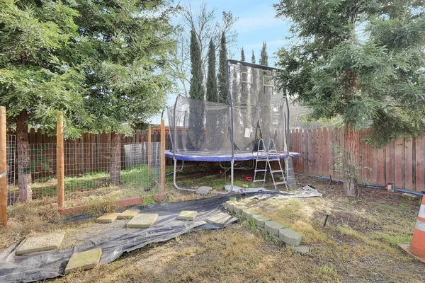 a view of backyard with wooden fence and a swing