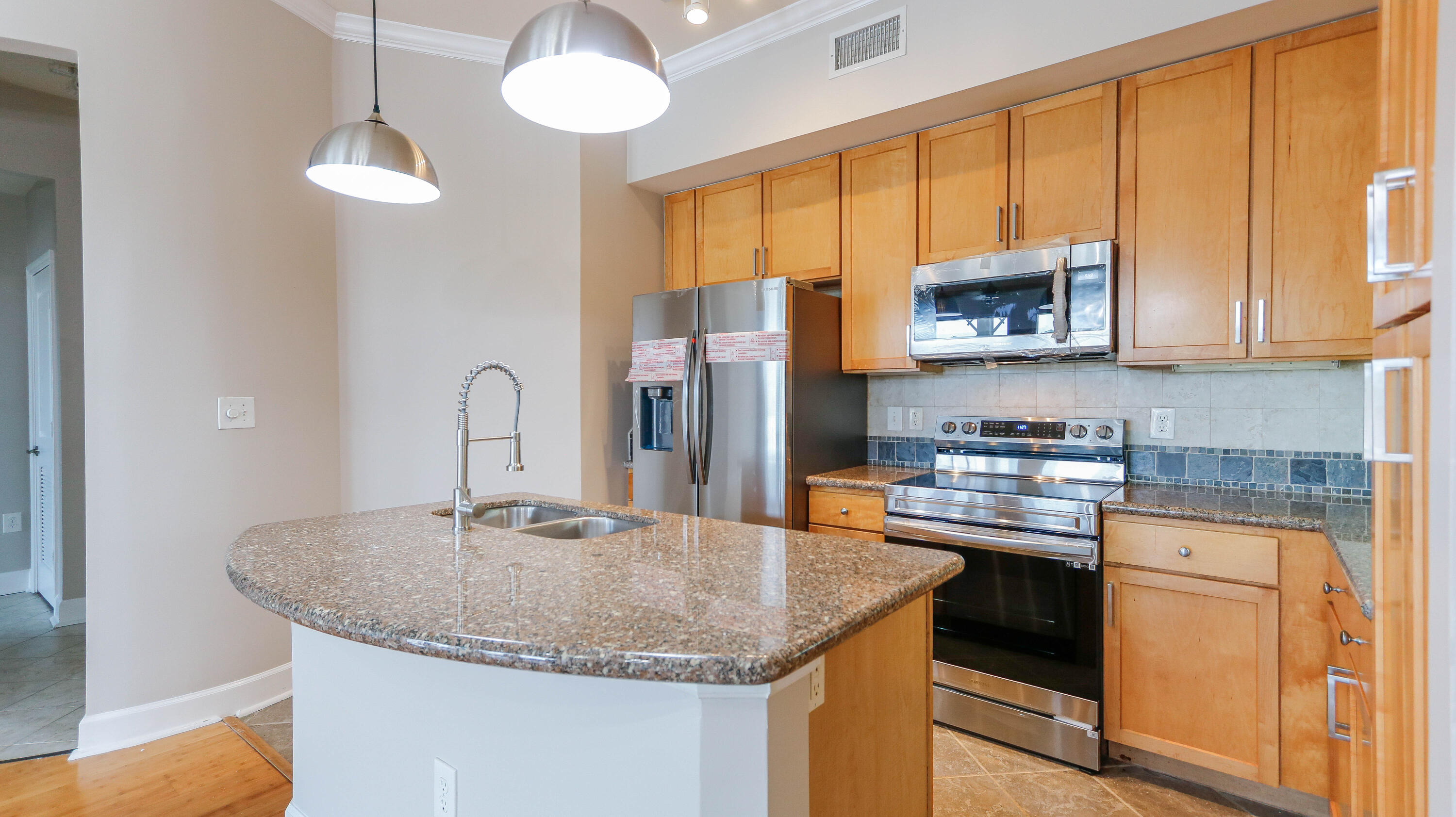 8700 Front Beach Road, Unit 1311 Panama City Beach, FL 32407 - Photo 22 of 65 a kitchen with stainless steel appliances granite countertop a sink a microwave cabinets and a refrigerator