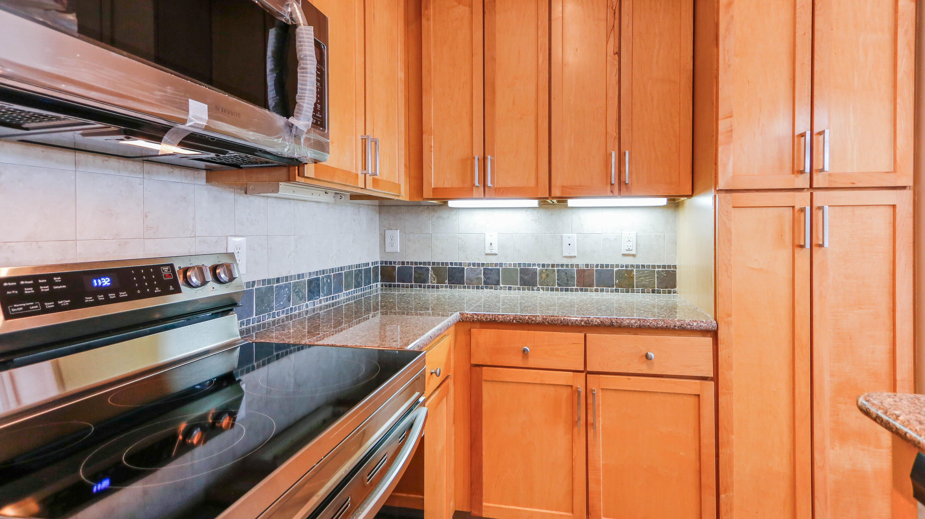 8700 Front Beach Road, Unit 1311 Panama City Beach, FL 32407 - Photo 24 of 65 a kitchen with a stove a microwave and cabinets